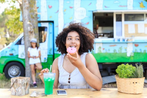 african woman eating donut and drinking coctail in nature - junk food stock pictures, royalty-free photos & images