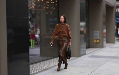 Aimee Song is seen outside Proenza Schouler show wearing golden Tiffany hardware necklace, brown wool pullover, brown leather skirt with matching...