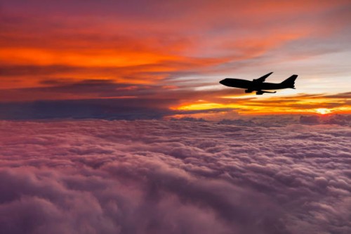 airplane at sunset above the clouds. - travel stock-fotos und bilder
