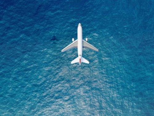 airplane flies over a sea - travel stock pictures, royalty-free photos & images