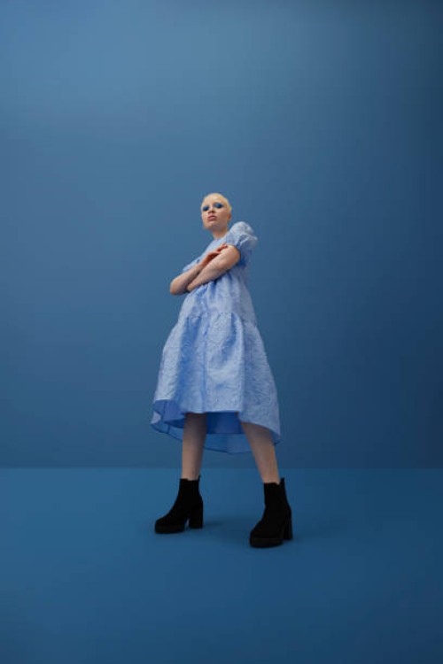 albino woman with arms crossed against blue background - fashion stock pictures, royalty-free photos & images