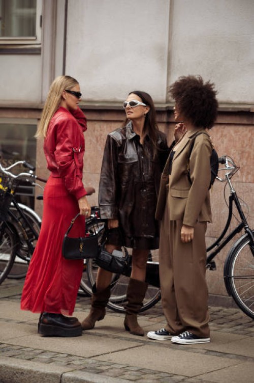 Alessa Winter wears red long skirt, red leather jacket, black shoes and black bag and Anna Winter wears long brown boots, brown leather skirt,...