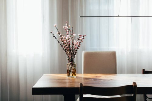 almond blossom twigs in a vase on wooden table in living room. - garden decoration stockfoto's en -beelden