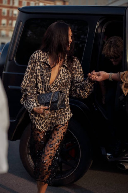 Amalie Bladt wears sheer black lace midi skirt, animal print shirt, black pointy flats and black bag outside the Baum und Pferdgarten show during day...