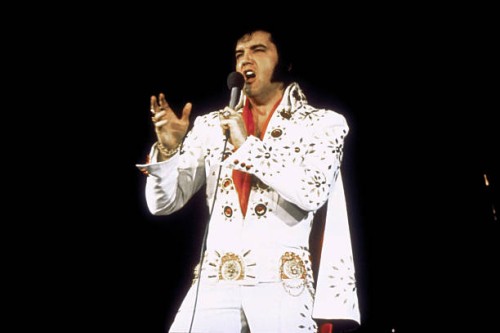 American singer Elvis Presley performing on tour.