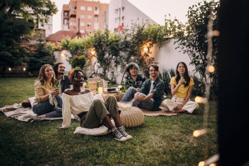 amis regardant un film sur le vidéoprojecteur dans le jardin de l’arrière-cour - garden decoration photos et images de collection