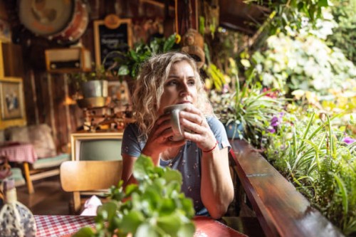 an adult woman enjoys tea on a garden terrace. - garden decoration stock pictures, royalty-free photos & images