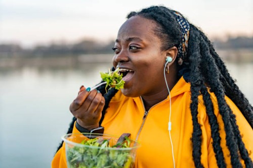 an african american woman eating fresh salad for lunch - food stock pictures, royalty-free photos & images