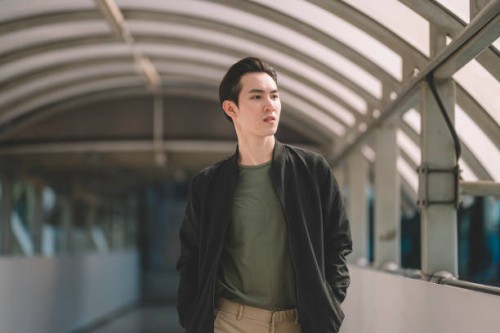 an asian chinese young man walking out from the sub way station in the day smiling - fashion stock pictures, royalty-free photos & images