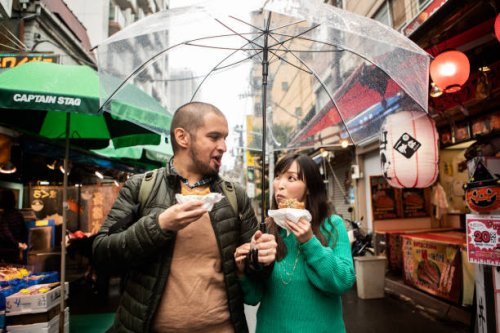 an internationally married couple who came to tsukiji for sightseeing while eating fried food - travel stock pictures, royalty-free photos & images