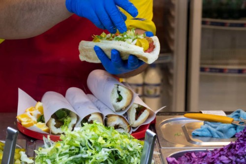 An Iranian-Arab cook prepares a sandwich for a client at a fast-food restaurant in an Arabian food street in the city of Ahvaz 817Km south of Tehran...