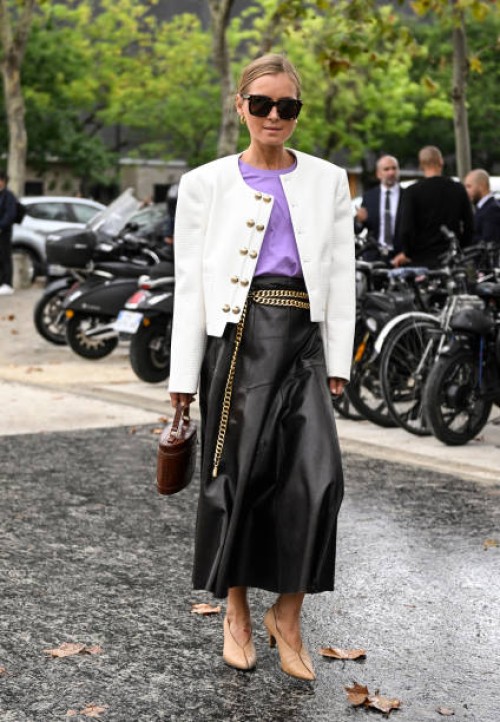 Anna Borisovna is seen wearing a white jacket, purple shirt, black leather skirt, gold belt, brown bag, tan shoes and black sunglasses outside the...