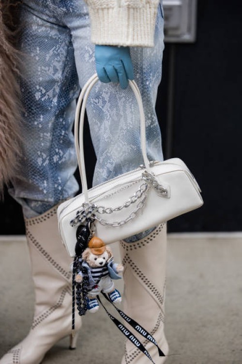 Anna Estrin wears white boots Isabel Marant, knit sweater Celine, jeans For all Mankind, white bag Alaia, blue gloves outside Ulla Johnson during New...