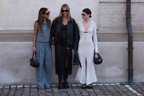Anna Winter is seen wearing aviator sunglasses with wide temples and orange lenses from Port Tanger, silver hoop earrings, a silver necklace with...