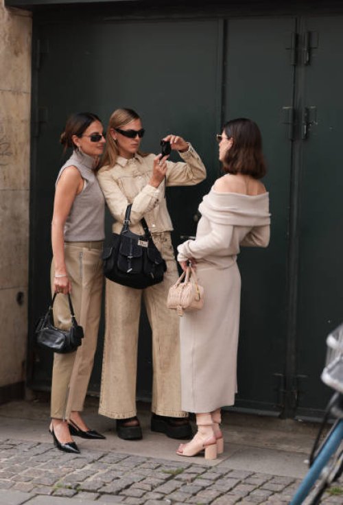 Anna Winter is seen wearing sunglasses with a fine black frame from Ray Ban, silver hoop earrings, a beige knitted tank top with turtleneck, two-tone...
