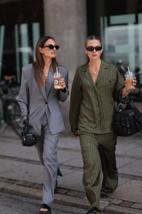 Anna Winter seen wearing black sunglasses, silver necklace, Edited grey fitted suit blazer, matching Edited grey loose suit pants, black leather bag...