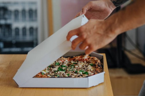 anonymous student opening a box of pizza he will eat during his study break - junk food stock pictures, royalty-free photos & images