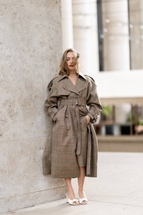 Anouchka Gauthier wears a beige checked coat and white heeled sandals outside Zimmermann show during Womenswear Spring/Summer 2025 as part of Paris...