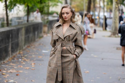 Anouchka Gauthier wears brown belted checkered coat, shorts outside Zimmermann during Womenswear Spring/Summer 2025 as part of Paris Fashion Week on...