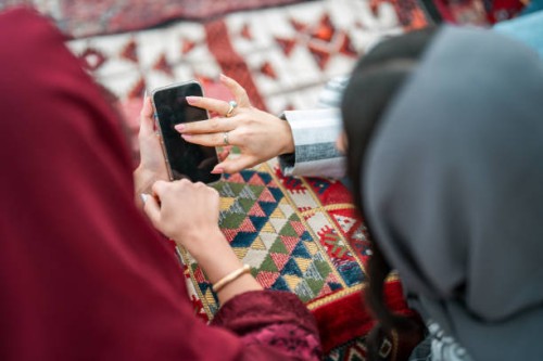 arabic young women engaging with smartphones in majlis - garden decoration stock pictures, royalty-free photos & images