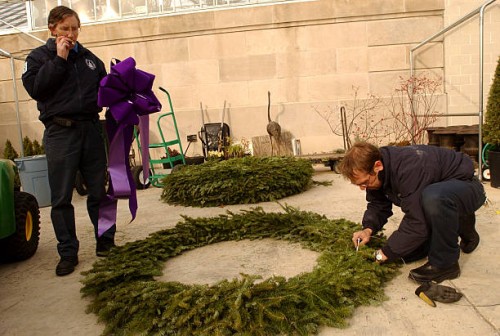 Architect of the Capitol employees, Ken Puza, left, and Brian Griffin, assemble a wreath to be hung as one of many on the front of the Botanic...