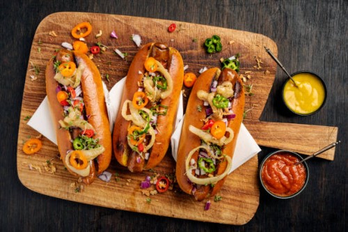artisan hot dogs in brioche rolls with pickles, onion and relishes. - food stock pictures, royalty-free photos & images