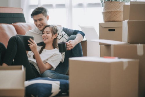 asia chinese couple sitting on floor resting after opening carton cardboard boxes in living room moving house - home decoration stock pictures, royalty-free photos & images