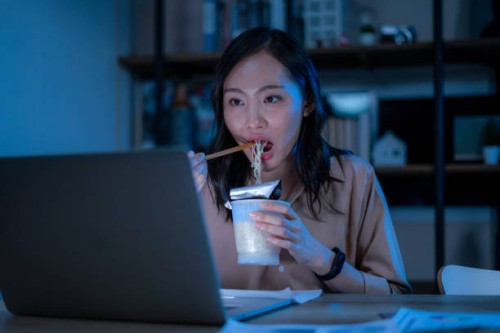 asia freelance smart business women eating instant noodles while working on laptop in living room at home at night - junk food stock pictures, royalty-free photos & images
