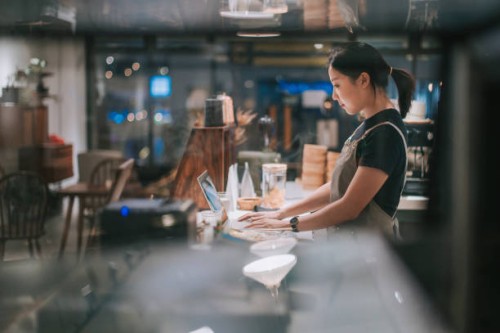 asian chinese female barista using laptop while enjoying dinner at coffee shop bar counter - food stock pictures, royalty-free photos & images