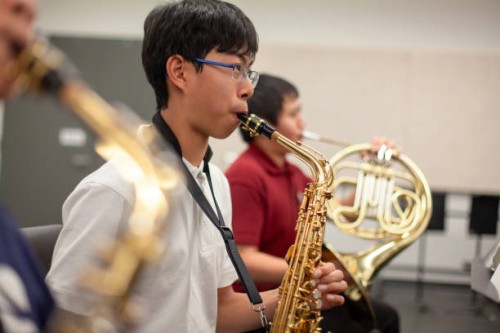 asian chinese teenage boy junior high student playing saxophone in band class in school orchestra - concert stock pictures, royalty-free photos & images