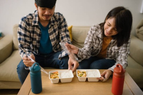 asian couple having lunch at home during quarantine. - junk food stock pictures, royalty-free photos & images