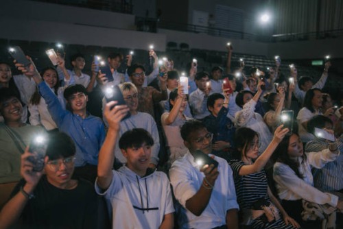 asian crowd with smartphone flash lights at concert - concert stockfoto's en -beelden