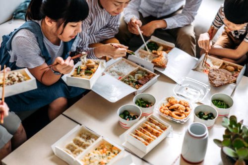 asian family eating takeout food in living room - junk food stock pictures, royalty-free photos & images