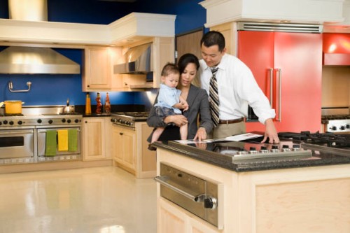 asian family looking at brochure in kitchen showroom - home decoration stockfoto's en -beelden