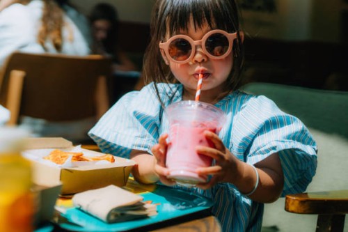 asian little girl in sunglasses drinking smoothie in restaurant - junk food stock pictures, royalty-free photos & images