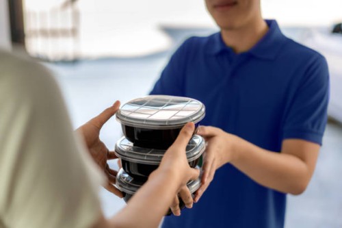 asian man delivering food in black boxes to customer home. - food stock pictures, royalty-free photos & images