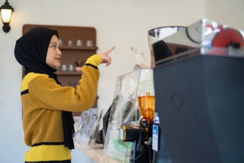 asian muslim woman orders a drink in a cafe - junk food stock pictures, royalty-free photos & images