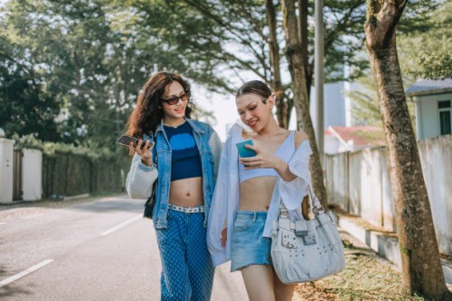asian transgender female friends holding smart phone walking on the street in the morning - fashion stock pictures, royalty-free photos & images