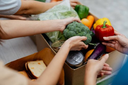 asian volunteers packing donated goods and groceries at food bank - food stock pictures, royalty-free photos & images