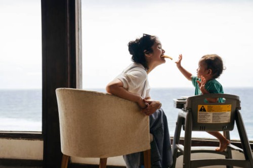 asian woman with her son sitting on the chair eating pizza - food stock pictures, royalty-free photos & images