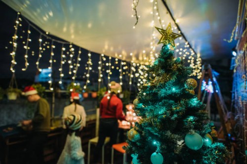 asiatische chinesische weibliche und männliche aufräumen tisch und warten auf nächsten abschnitt geschenk-austausch und feiern weihnachtsfeier auf dem dach des hauses - garden decoration stock-fotos und bilder