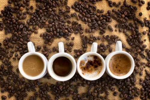 assorted coffee drinks in cups on coffee beans background - coffee stockfoto's en -beelden