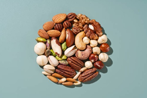 assorted nuts organized in circle on green background - food stockfoto's en -beelden