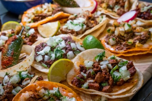 assortment of delicious authentic tacos, birria, carne asada, adobada, cabeza and chicharone, arranged with lime slices, onion, and roasted chili pepper - junk food stock pictures, royalty-free photos & images