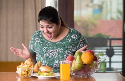 astonished woman looking at unhealthy food - junk food stock pictures, royalty-free photos & images