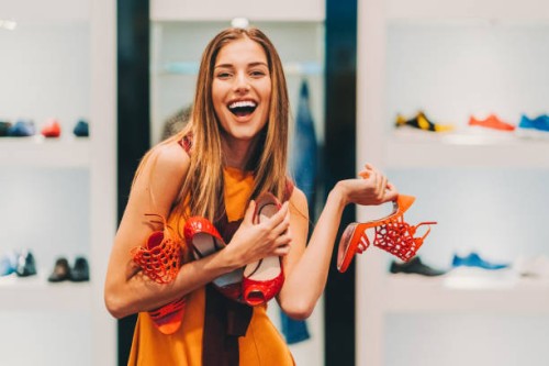attractive woman in the shoe store holding a pile of new shoes - fashion stock pictures, royalty-free photos & images
