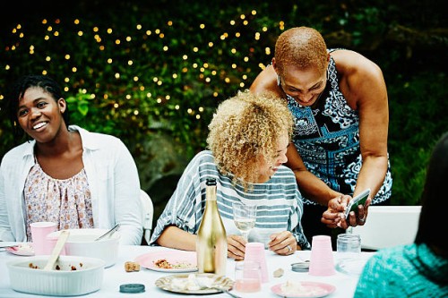 aunt showing pictures on smartphone to niece - garden decoration stock pictures, royalty-free photos & images