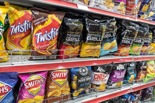 Australia, Sydney, Central Business District CBD convenience store shelves food junk snack potato chips bags competing brands packaging sale retail...