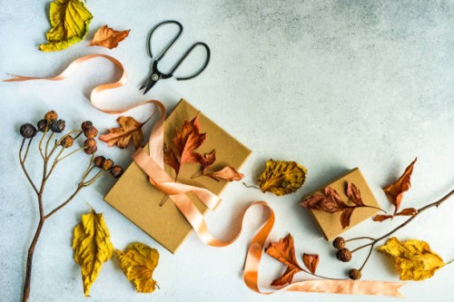 autumnal gift box tied with a ribbon and dried autumn leaf decorations on a table - home decoration stock pictures, royalty-free photos & images