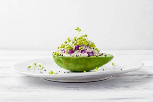 avocado garden stuffed with tuna, mayonnaise, red onion, black sesame seeds and radish sprouts - food stock pictures, royalty-free photos & images